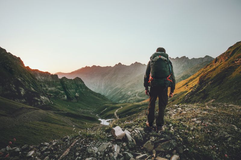man hiking sunset mountains heavy backpack Proactive Apathy