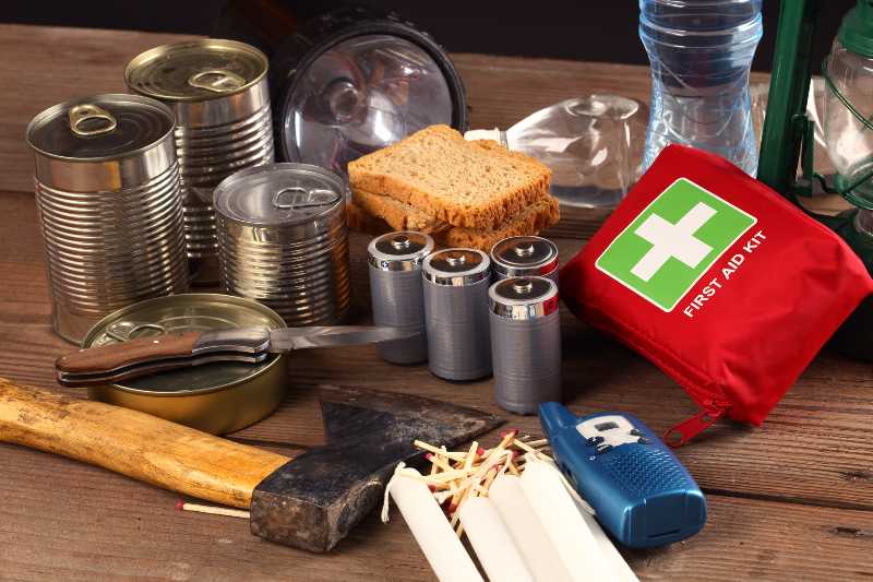 Items for emergency on wooden table | Step Two: Build a Survival Kit