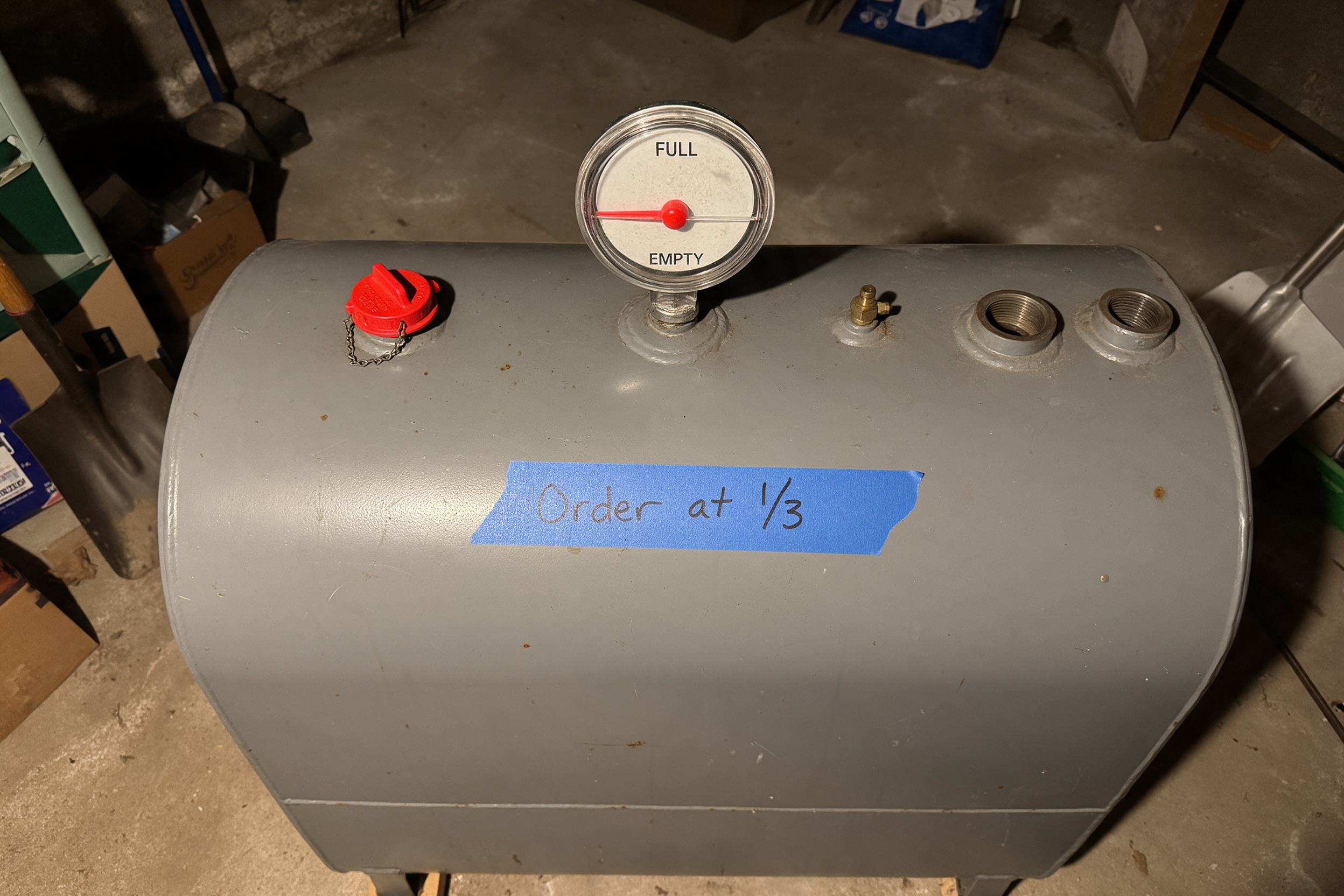 Home heating oil tank gauge reading about one quarter full with an "Order at 1/3" tape strip